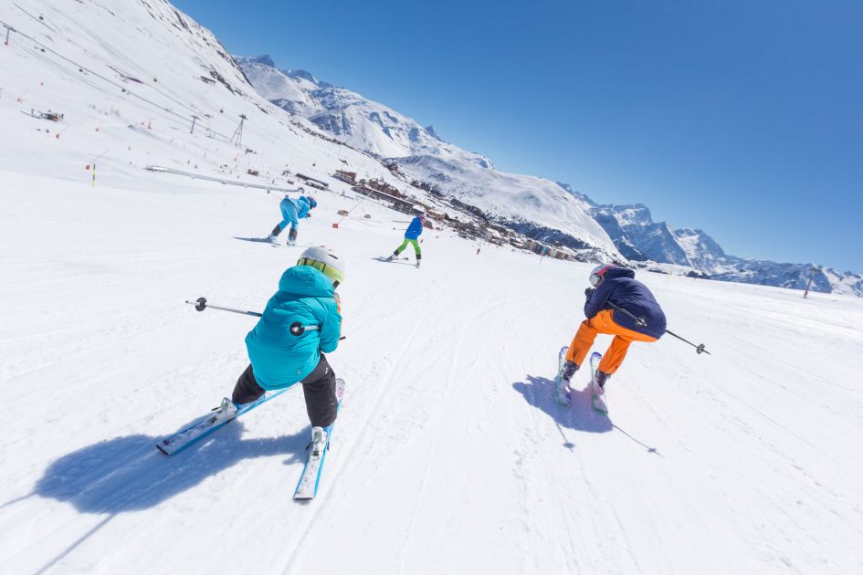 Family ski holidays to Alpe d'Huez, a family of skiers sees kids racing parents down to the resort.