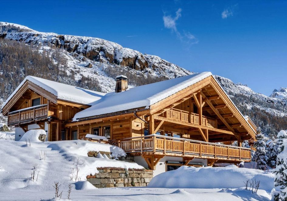 Chalet Le Tabuc's light alpine wooden exterior, surrounded by snow and mountains in the background - perfect for a luxury self catering ski holiday.