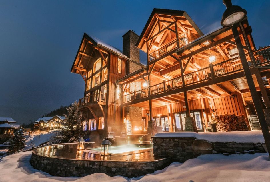 Bighorn Revelstoke, exterior at dusk. Outdoor hot tub lit up by the lights of this luxury lodge in Canada.