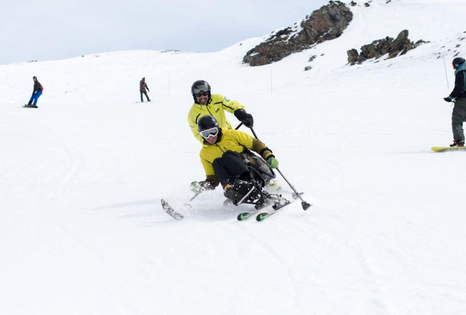 A sit-skier and guide skiing on one of the pistes in Val Thorens