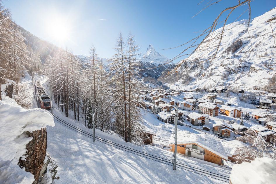 Header image for 5 Reasons to Visit Zermatt blog, showcasing the snowy village with the Matterhorn in the background.