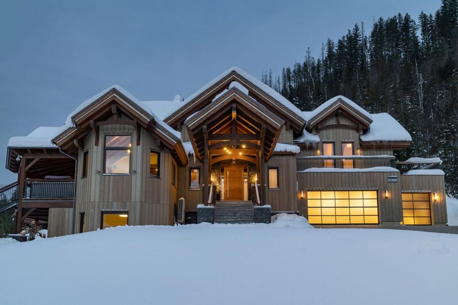 The exterior of Flying Moose Chalet in Revelstoke in the evening surrounded by snow