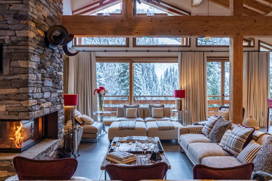 Living room photo of Chalet Berlioz with a wood-burning fireplace, soft furnishings, exposed beams and snowy views out the large windows.