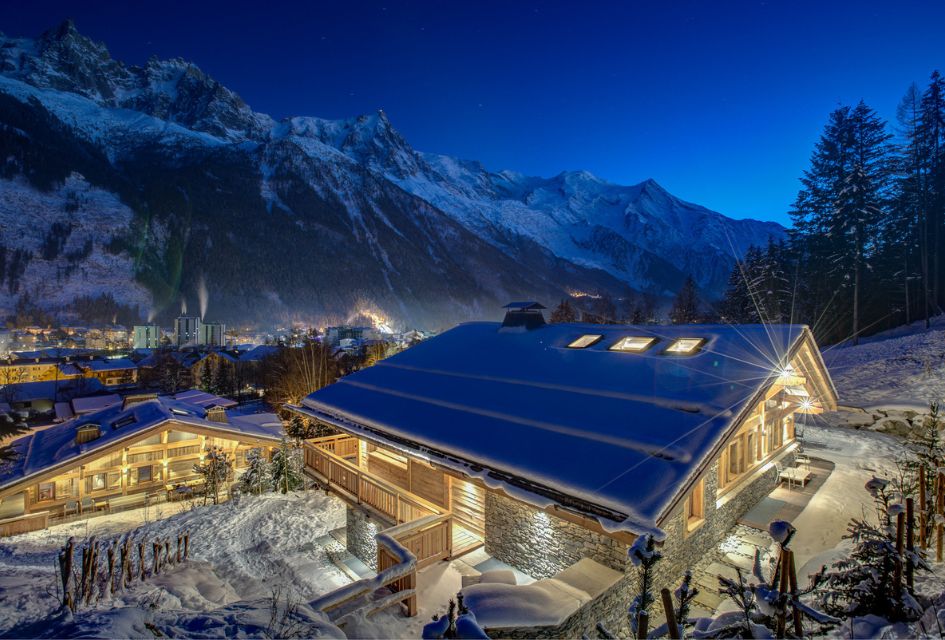 Le Hameau des Plans exterior in the snow, with stars visible above the mountains