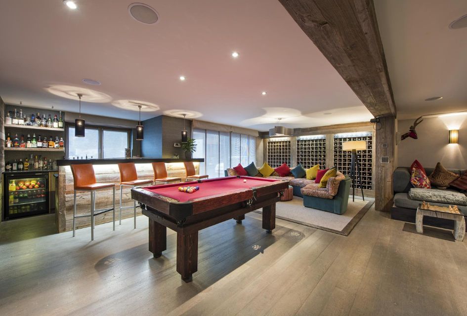 Pool table and lounge area of The Lodge in Verbier, complete with a stocked bar, making it a top luxury corporate ski chalet.