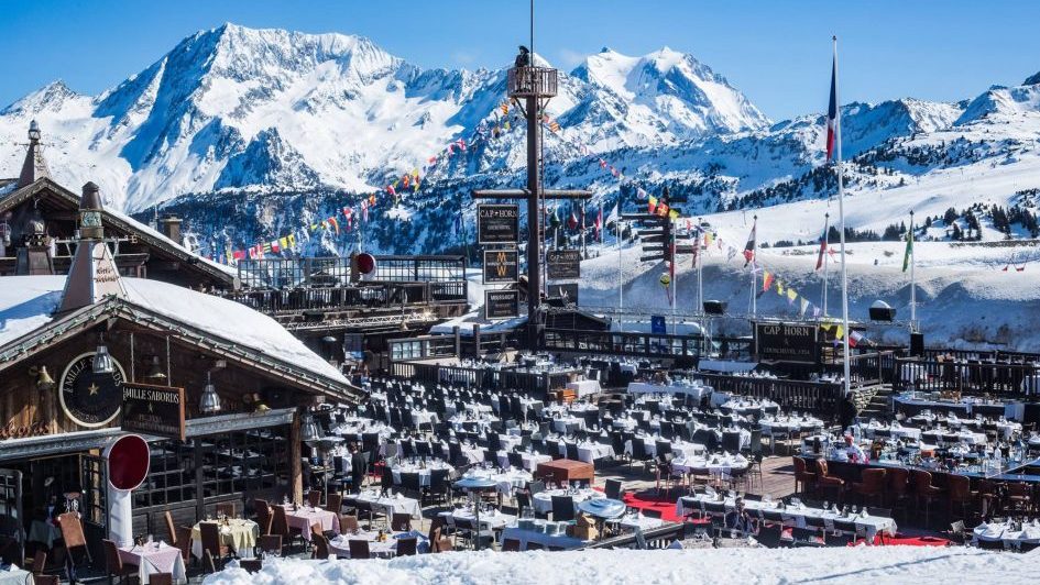 View of the Cap Horn terrace with a snowy mountain backdrop in Courchevel 1850.