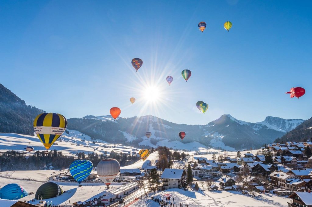 Hot air balloon festival amongst sunny blue skies and snow mountain scapes 