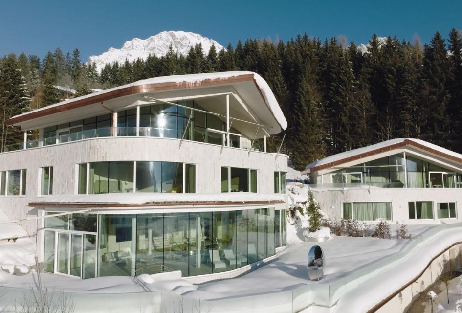 Julisam Estate, one of the top luxury eco chalets in the Swiss Alps, with its curved walls, large windows, and impressive design.