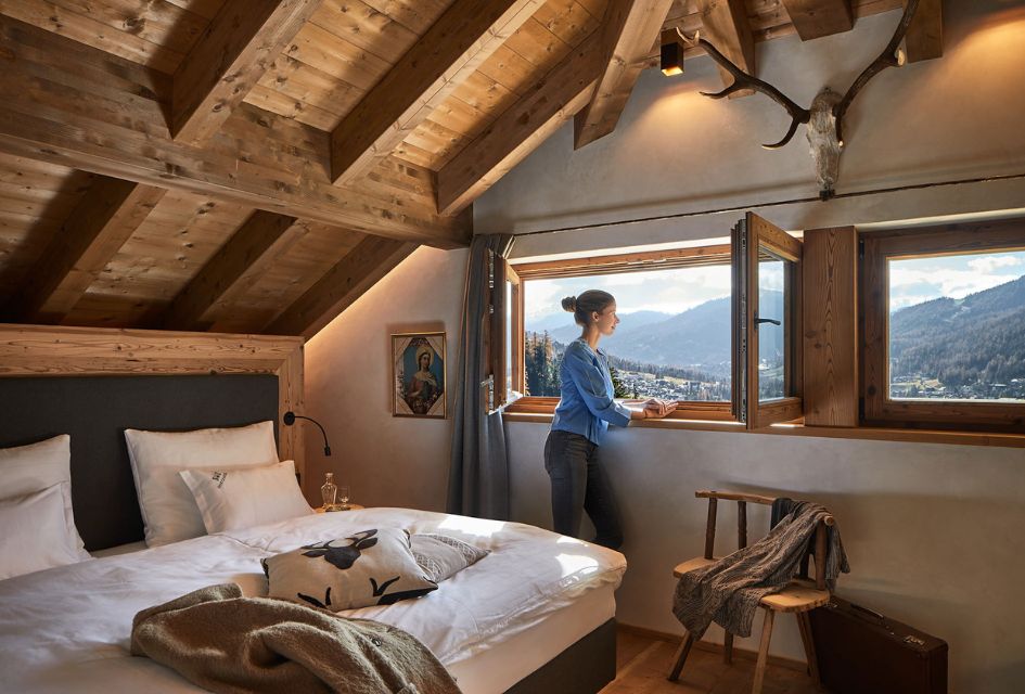 Inside the luxury chalet bedroom on the top floor of Chalet Sotciatel in Alta Badia looking out on the Gardenaccia Massif. 